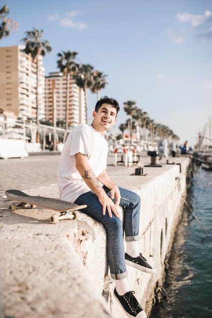 Retrato de un joven feliz con una patineta