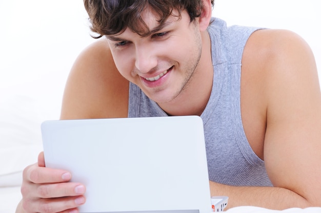 Retrato de un joven feliz con portátil