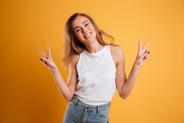 Retrato de una joven feliz que muestra gesto de paz