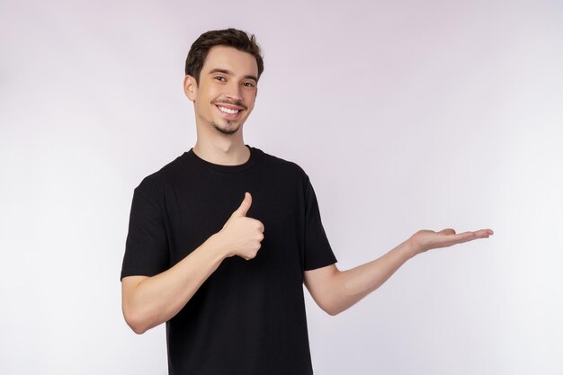 Retrato de un joven feliz y sonriente que presenta y muestra su texto o producto aislado de fondo blanco