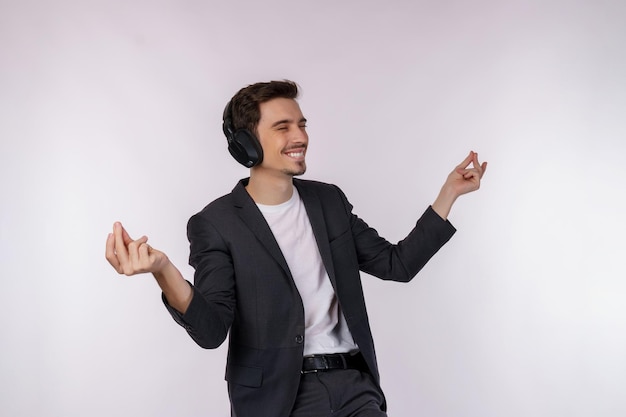 Foto gratuita retrato de un joven feliz usando auriculares y disfrutando de la música sobre fondo blanco.