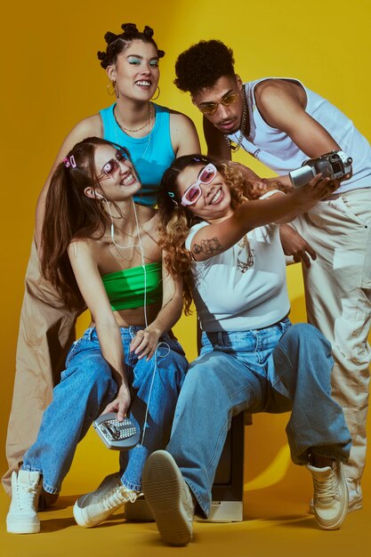 Retrato de un joven grupo de amigos al estilo de la moda de los años 2000 posando con cámara