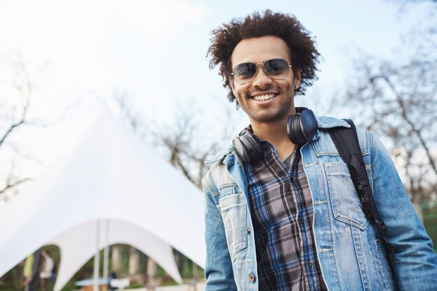 Retrato de joven guapo estudiante afroamericano con peinado afro sonriendo