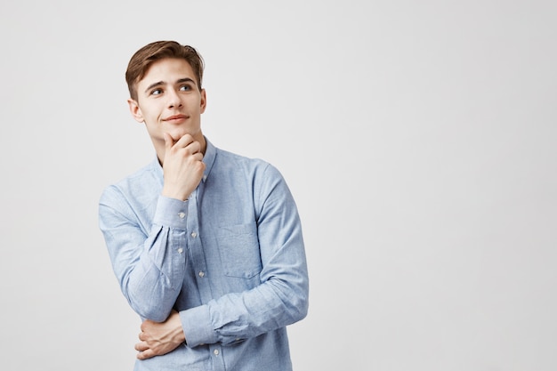 Foto gratuita retrato de joven guapo con la mano en el mentón