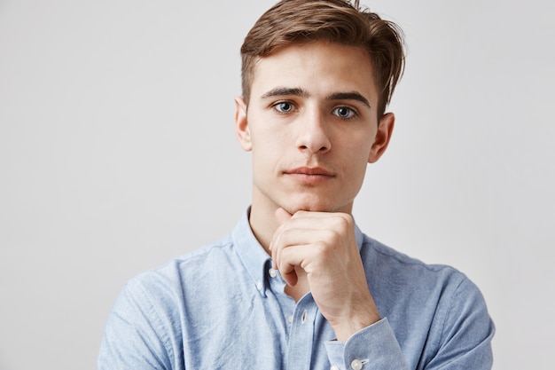 Foto gratuita retrato de joven guapo con la mano en el mentón