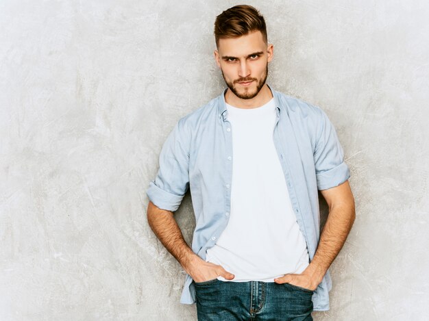 Retrato de joven guapo modelo vistiendo ropa casual camisa. Hombre elegante de moda posando