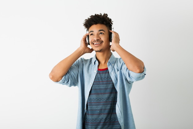 Retrato de joven guapo negro escuchando música con auriculares en blanco