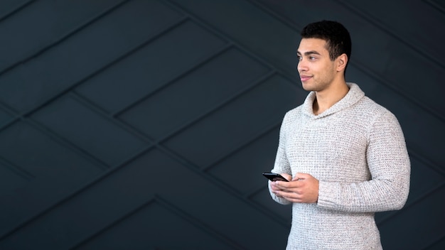 Retrato de joven guapo sosteniendo su teléfono