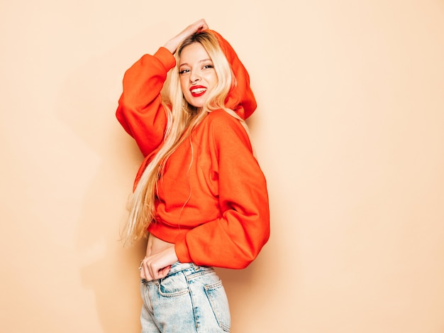 Retrato de joven hermosa chica mala inconformista en sudadera con capucha roja de moda y arete en la nariz. Modelo positivo