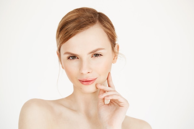 Retrato de joven hermosa chica tocando la cara. Tratamiento facial. Cosmetología de belleza y cuidado de la piel.