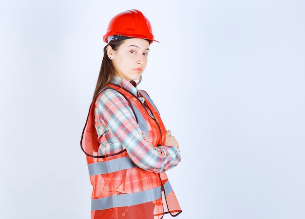 Retrato de joven hermosa ingeniera en casco posando para la cámara.