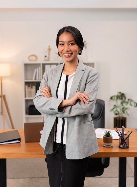 Retrato de joven hermosa mujer asiática de negocios en la oficina brazos cruzados