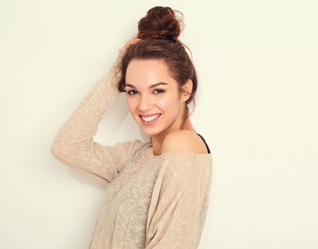 Retrato de joven hermosa mujer morena modelo chica con maquillaje desnudo en ropa de verano posando junto a la pared.