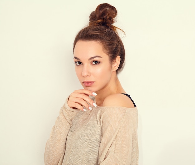 Retrato de joven hermosa mujer morena modelo chica con maquillaje desnudo en ropa de verano posando junto a la pared.