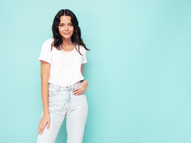 Retrato de joven hermosa mujer sonriente en ropa de verano de moda Mujer sexy despreocupada posando cerca de la pared azul en el estudio Modelo positivo divirtiéndose en el interior Alegre y feliz