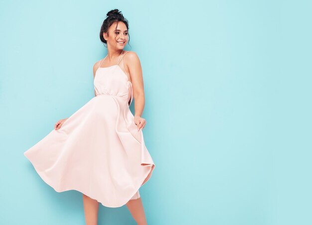 Retrato de joven hermosa mujer sonriente en vestido de verano de moda Mujer sexy despreocupada posando cerca de la pared azul en el estudio Modelo positivo divirtiéndose en el interior Alegre y feliz