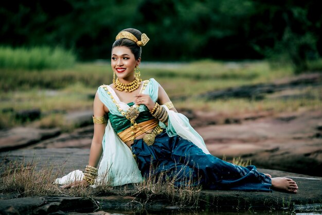 Retrato joven hermosa mujer vestida con traje tradicional con adorno posando en la naturaleza en Tailandia