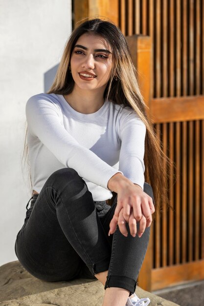 Un retrato de una joven hermosa sentada en la roca Foto de alta calidad