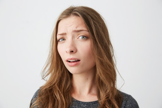 Retrato de joven hermosa sospechosamente con la boca abierta.