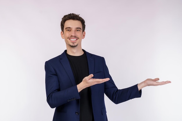 Retrato de un joven hombre de negocios feliz y sonriente que presenta y muestra su texto o producto aislado de fondo blanco