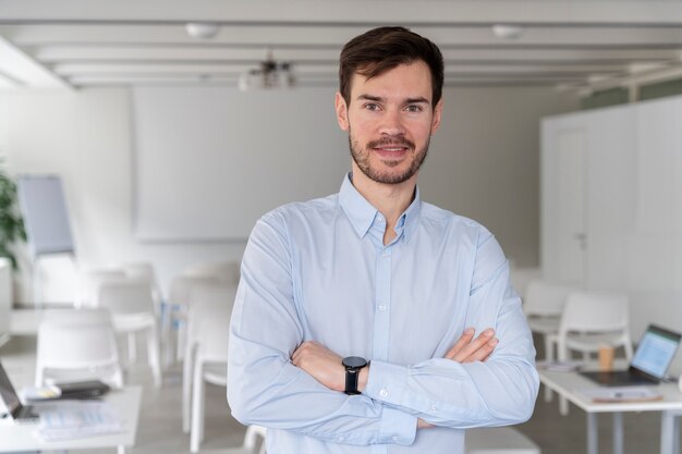 Retrato, de, joven, hombre de negocios, posar, con, brazos cruzados