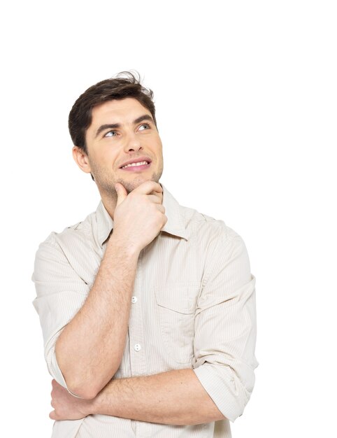 Retrato del joven hombre de pensamiento sonriente busca en casuals aislado sobre fondo blanco.