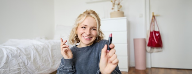 Retrato de una joven influyente en las redes sociales grabando un video con productos de belleza que la muestran