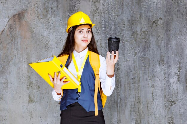 Retrato de joven ingeniero en hardhat tomando café. foto de alta calidad