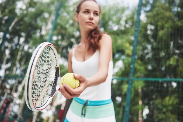 Retrato de un joven jugador de tenis de pie listo para servir.