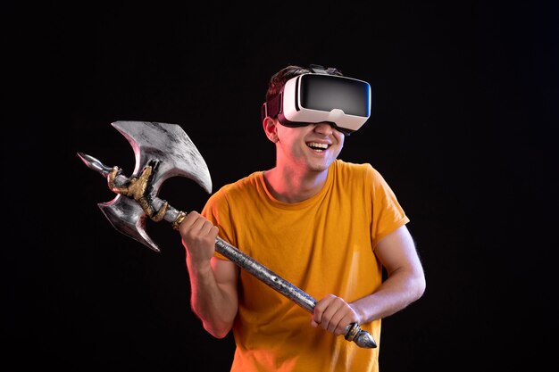 Retrato de joven jugando vr con hacha de batalla en los vikingos samurai oscuros