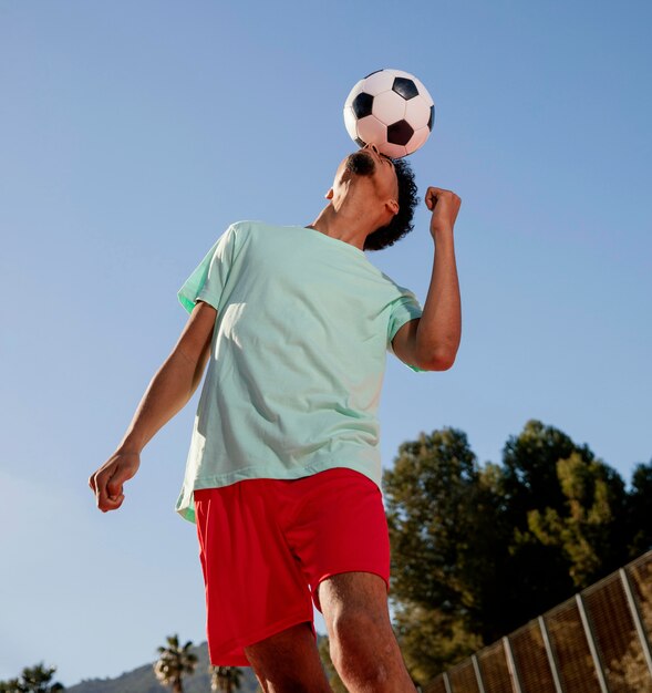 Retrato, joven, jugar al fútbol, con, cabeza