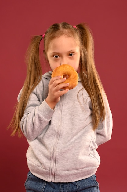 Foto gratuita retrato de joven linda comiendo donuts