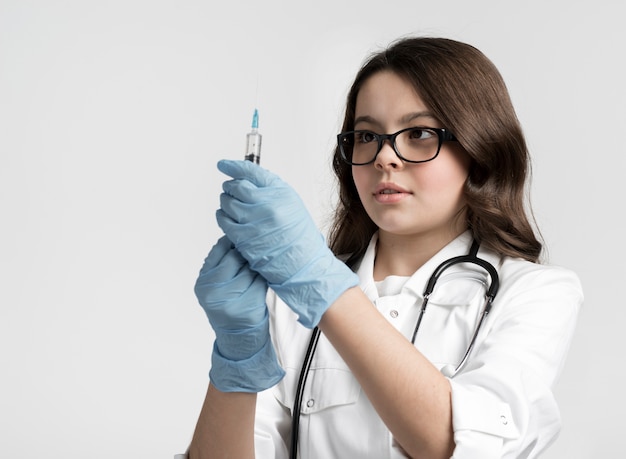 Retrato de joven linda con jeringa y guantes quirúrgicos