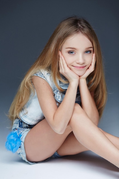 Retrato de joven linda en shorts de jeans y camiseta.