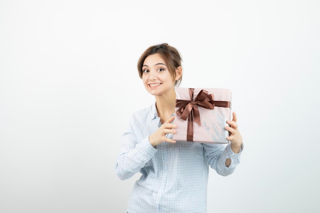 Retrato de una joven linda sosteniendo una caja de regalo con cinta. foto de alta calidad