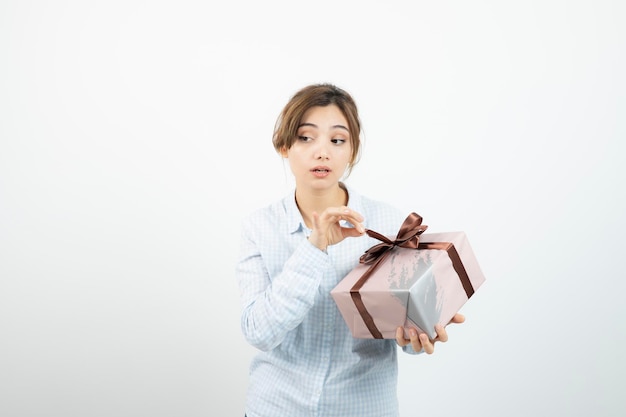 Retrato de una joven linda sosteniendo una caja de regalo con cinta. foto de alta calidad