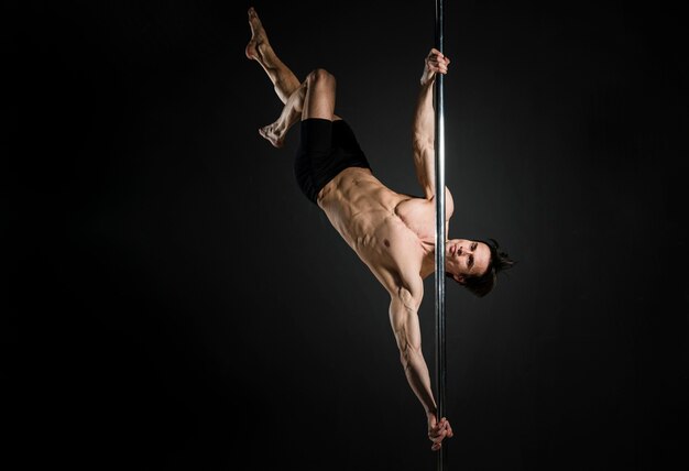 Retrato de joven macho haciendo un pole dance