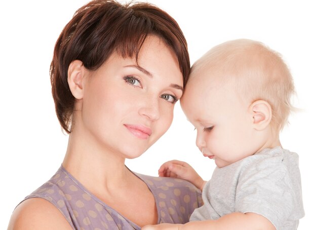 Retrato de la joven madre bonita con bebé sobre fondo blanco.