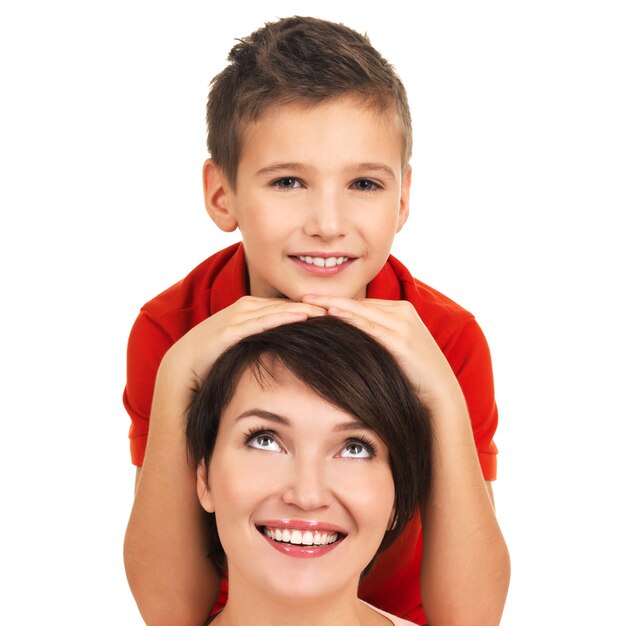 Retrato de una joven madre feliz con su hijo de 8 años sobre fondo blanco.