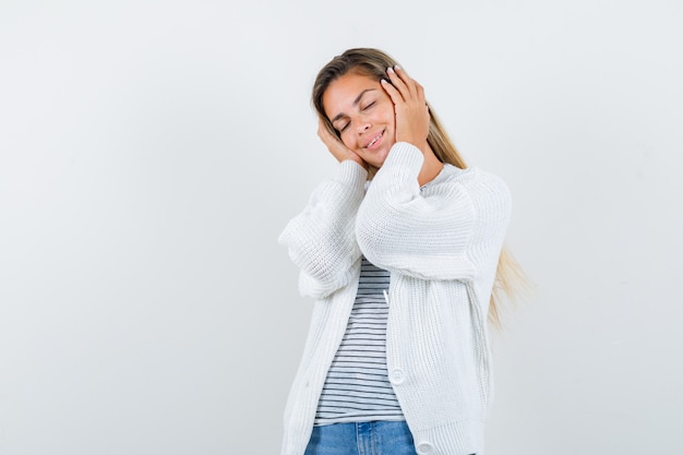 Foto gratuita retrato de joven manteniendo las manos en las orejas en camiseta, chaqueta y mirando pacífica vista frontal