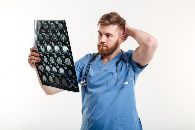 Retrato de un joven médico analizando una tomografía computarizada