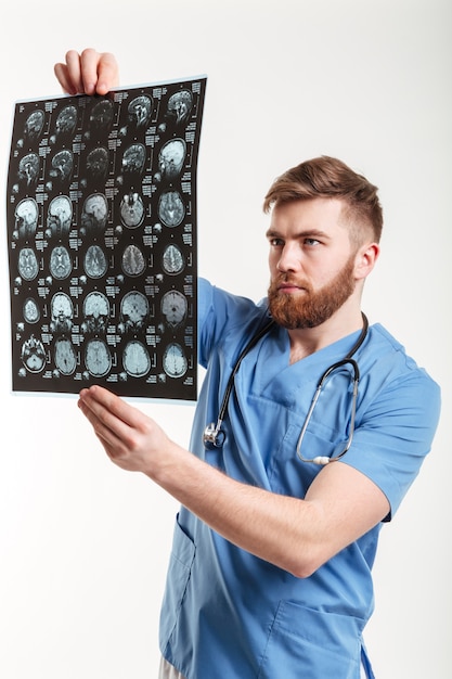 Retrato de un joven médico analizando una tomografía computarizada