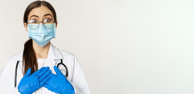 Foto gratuita retrato de un joven médico sorprendido y asombrado mirando con fascinación tomados de la mano en el standi del corazón