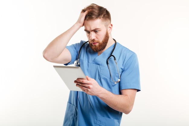 Retrato de un joven médico sorprendido en uniforme azul