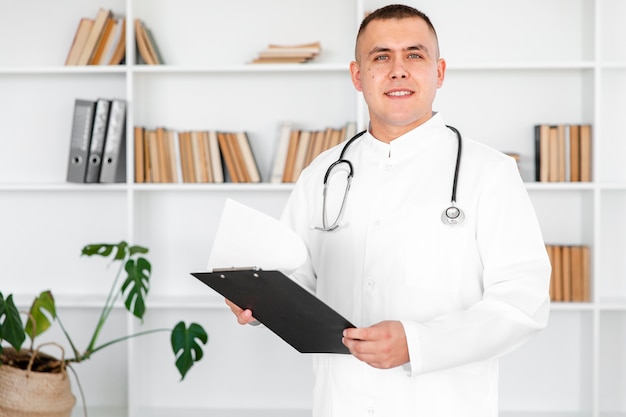 Retrato de joven médico sosteniendo un portapapeles