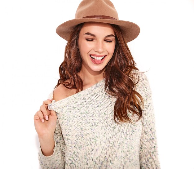 Retrato de joven modelo elegante chica en ropa casual de verano en sombrero marrón con maquillaje natural aislado. ans mostrando su lengua