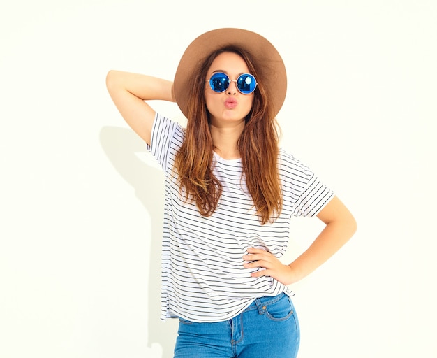 Retrato de joven modelo elegante mujer riendo en ropa casual de verano en sombrero marrón aislado en la pared blanca