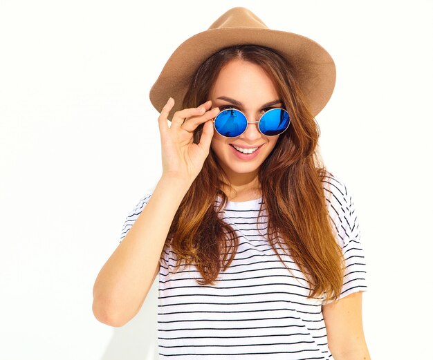 Retrato de joven modelo elegante mujer riendo en ropa casual de verano en sombrero marrón aislado en la pared blanca