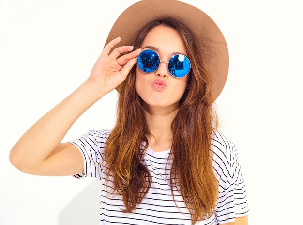 Retrato de joven modelo elegante mujer riendo en ropa casual de verano en sombrero marrón aislado en la pared blanca