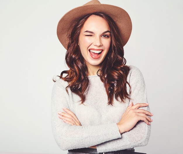 Retrato de joven modelo elegante riendo en ropa casual gris de verano en sombrero marrón con maquillaje natural